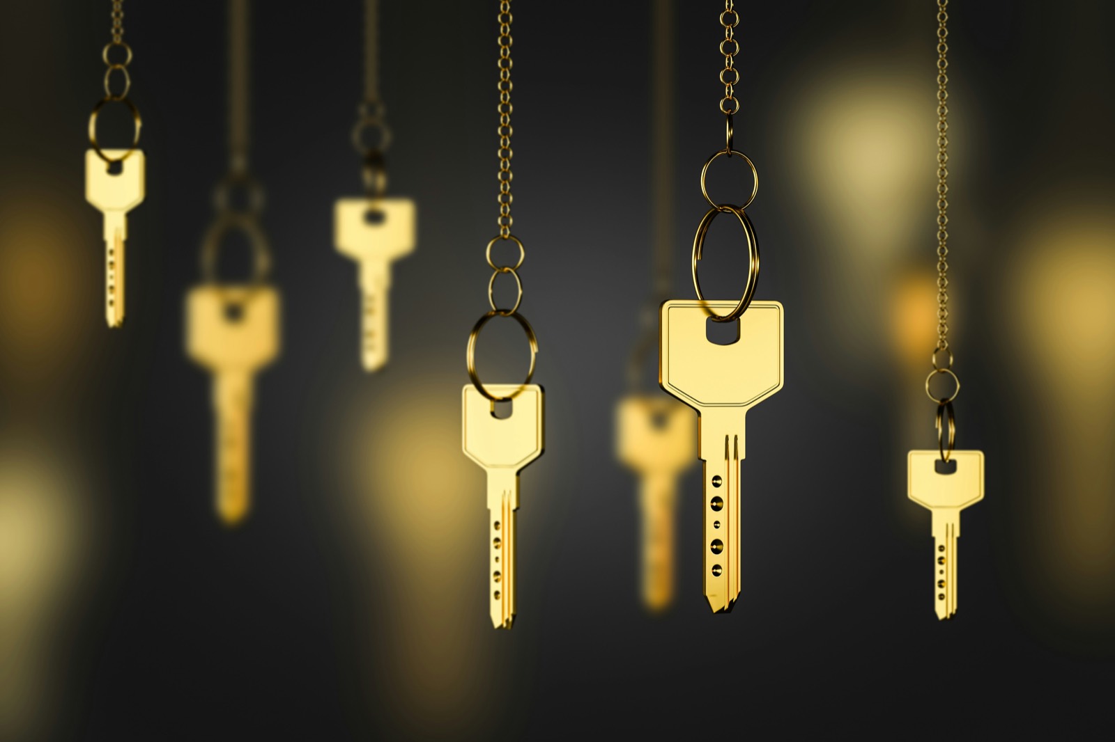 Brass keys hanging on chains against the dark